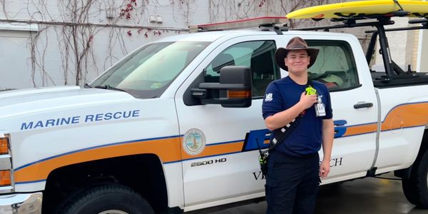 DJ Dees standing in front of a Virginia Beach EMS Truck