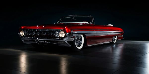 Shiny red vintage convertible car with whitewall tires.
