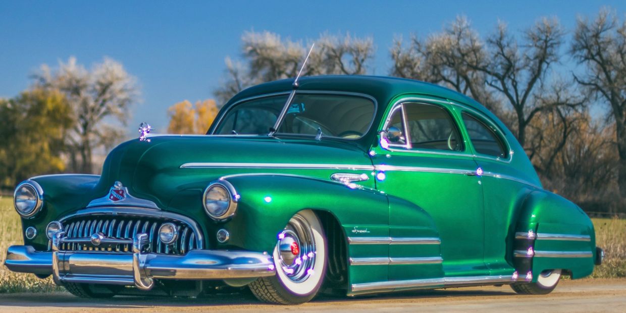 Shiny green classic car with whitewall tires.