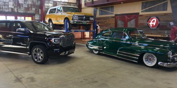 Three classic and modern vehicles in a garage.