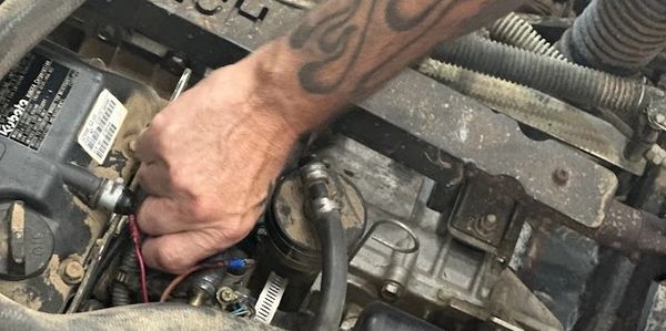 Hand fixing a UTV engine. 