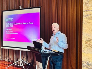 A man giving a presentation about steel in China.