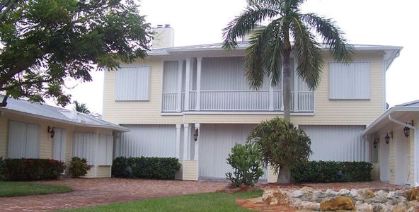 Accordion hurricane shutters on second story house