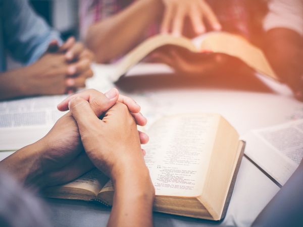 A group of people reading from the bible and praying