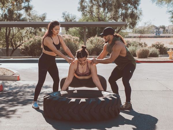 Coaches Naomi and Godeyvio training an athlete.