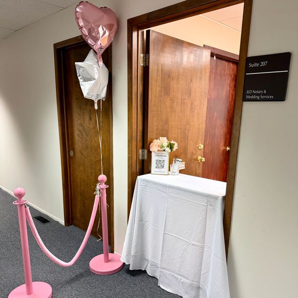 Entrance to a wedding services office with balloons and a decorated table.