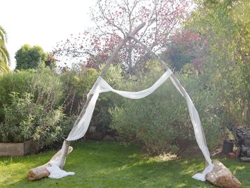 Outdoor fabric arch setup in a garden.