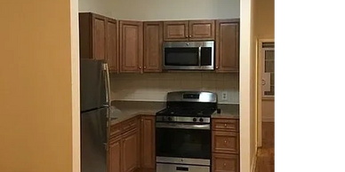 Modern kitchen with stainless steel appliances and wooden cabinets.