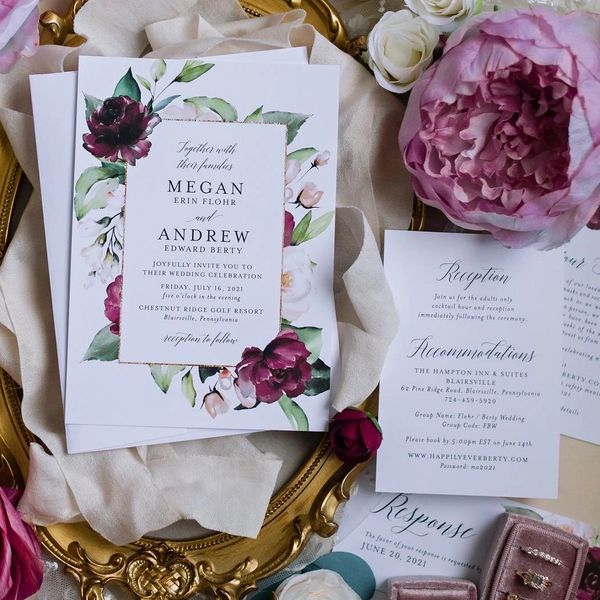 Elegant floral wedding invitations with pink and purple flowers.