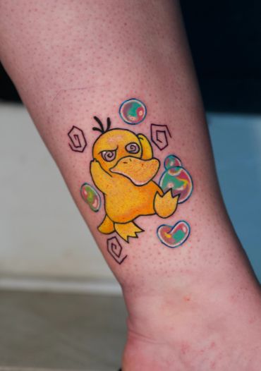 Colorful tattoo of the Pokémon Psyduck with bubbles on skin.