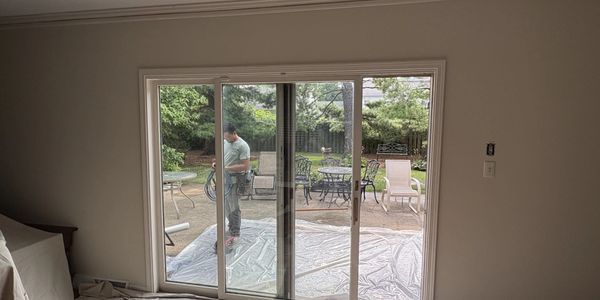 Person working outside near patio furniture and plastic covering.