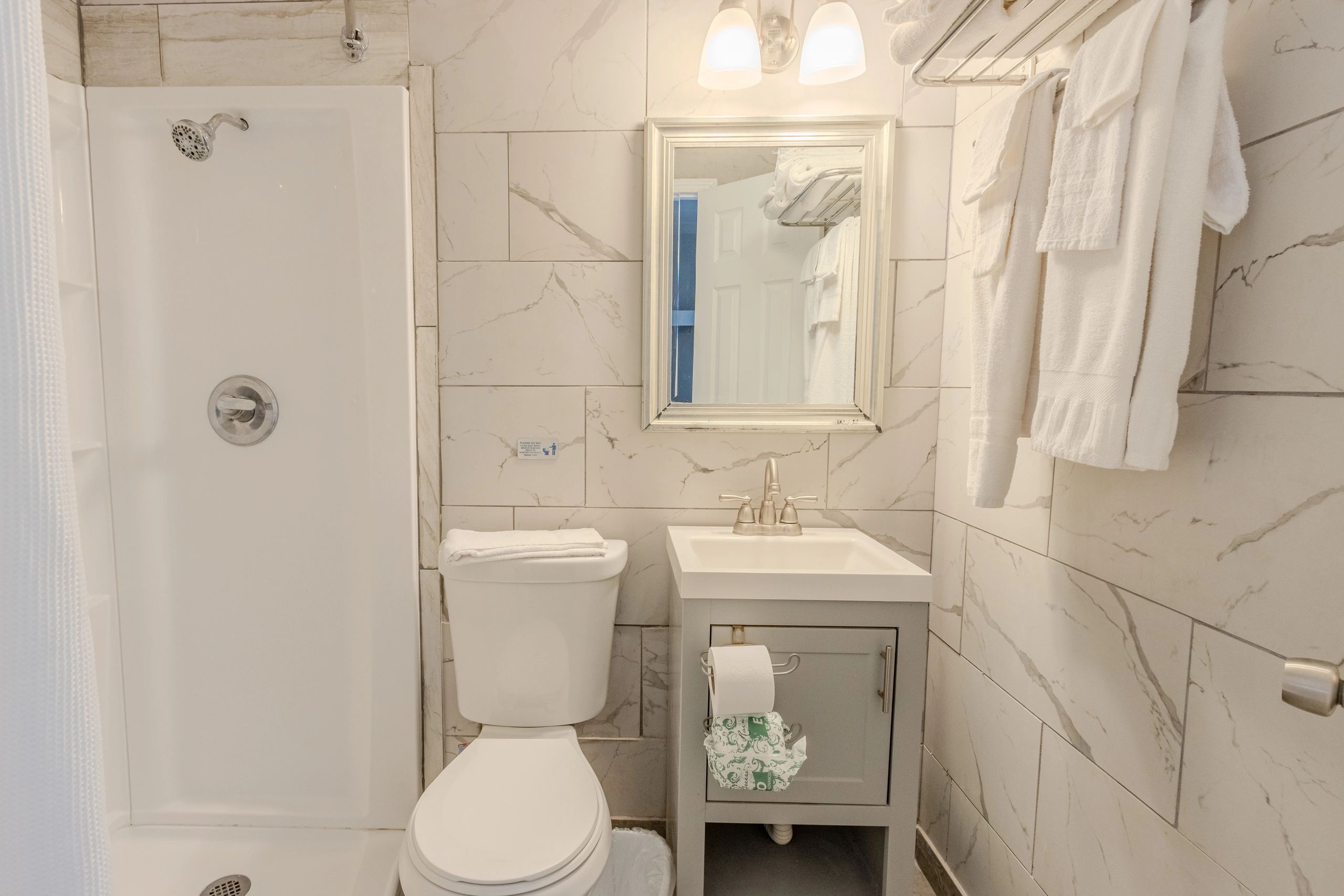 A clean bathroom with a toilet, shower, and sink