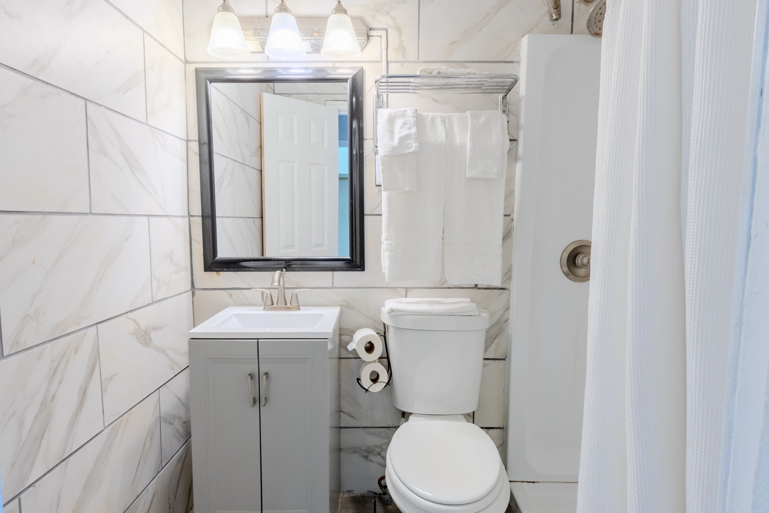 A clean bathroom with a toilet, sink, and shower