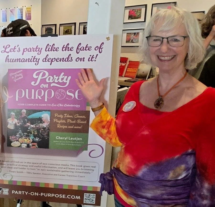 Author points to sign that reads: Let's party like the fate of humanity depends on it! 