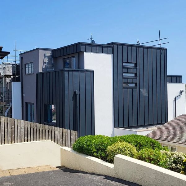 Modern black and white house with clean lines and greenery.