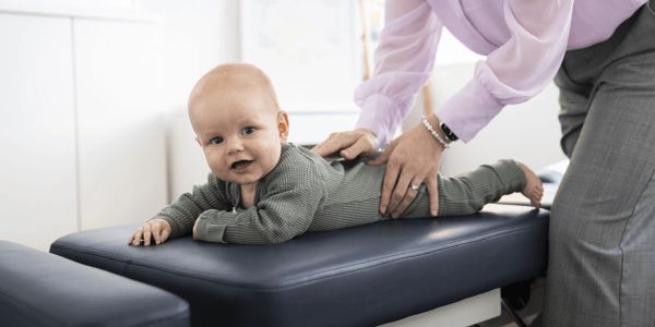 Baby receiving a chiropractic adjustment.