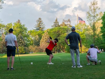 Golfers with American flag in the distance.