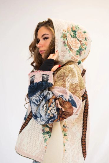 Woman wearing a floral and patterned hooded jacket.