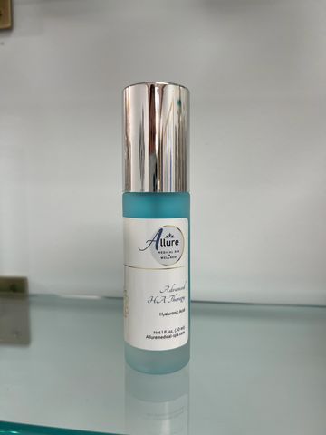 A sleek blue bottle of Allure skincare serum with a silver cap.
