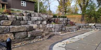 Armour Stone retaining walls with Unilock pavers around pool.