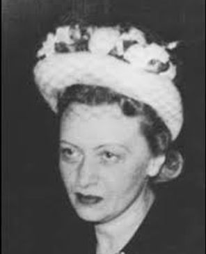 Black-and-white portrait of a woman wearing a floral hat.