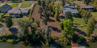 Aerial view of a residential area with houses, trees, and a water body.