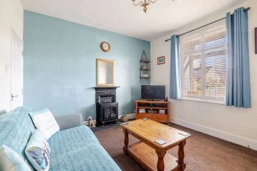 Cozy living room with blue walls and wooden furniture.