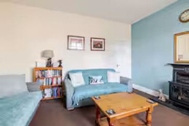 Cozy living room with blue sofa and wooden coffee table.