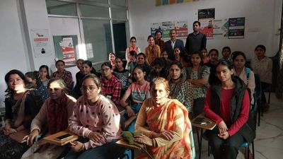 A group of students and teachers in a classroom setting.