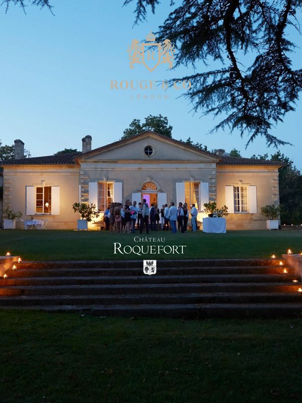 Evening event at Château Roquefort with guests and torch-lit steps.