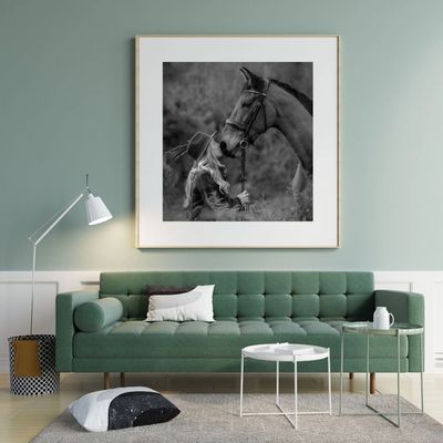 Modern living room with green sofa and black-and-white horse photo.