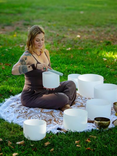 Melissa playing crystal singing bowls at outdoor sound bath in Folsom, CA