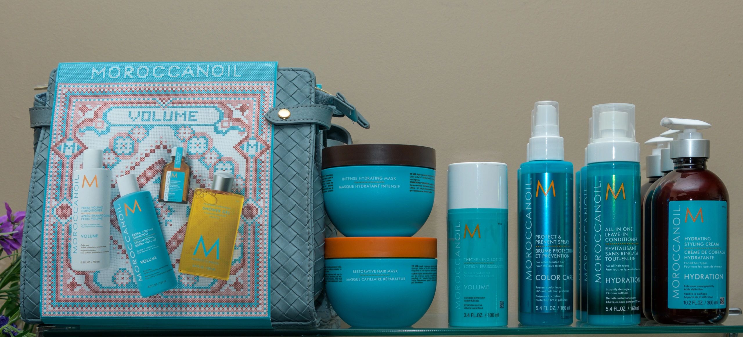 A collection of Moroccanoil hair care products arranged on a glass shelf.