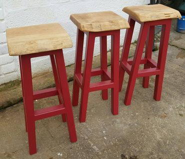 Oak topped with painted legged bar stools. 