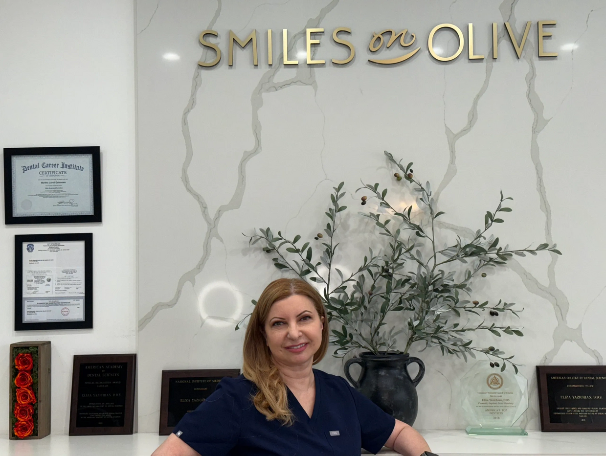 A woman smiling in a dental clinic named Smiles on Olive.