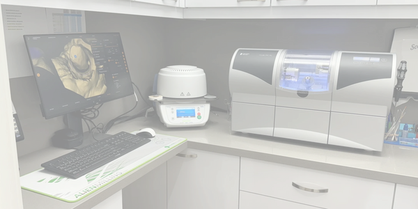 Dental lab with 3D imaging and milling machine setup.