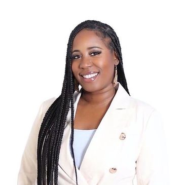 Smiling woman with long braided hair wearing a white blazer.