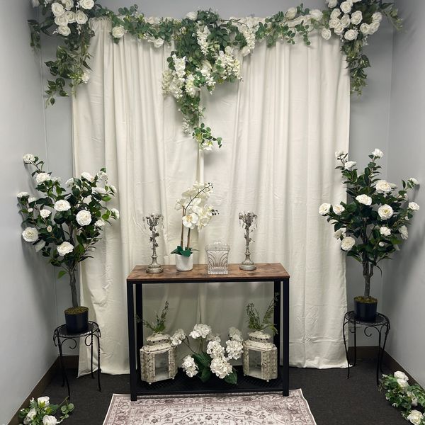 Elegant floral arrangement with white flowers and decorative lanterns in a cozy corner.