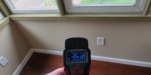 Moisture meter detecting elevated moisture levels near a window in an Eastern Iowa home