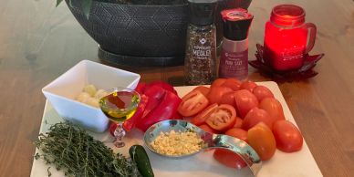 Fresh ingredients including tomatoes, garlic, and herbs on a kitchen counter.