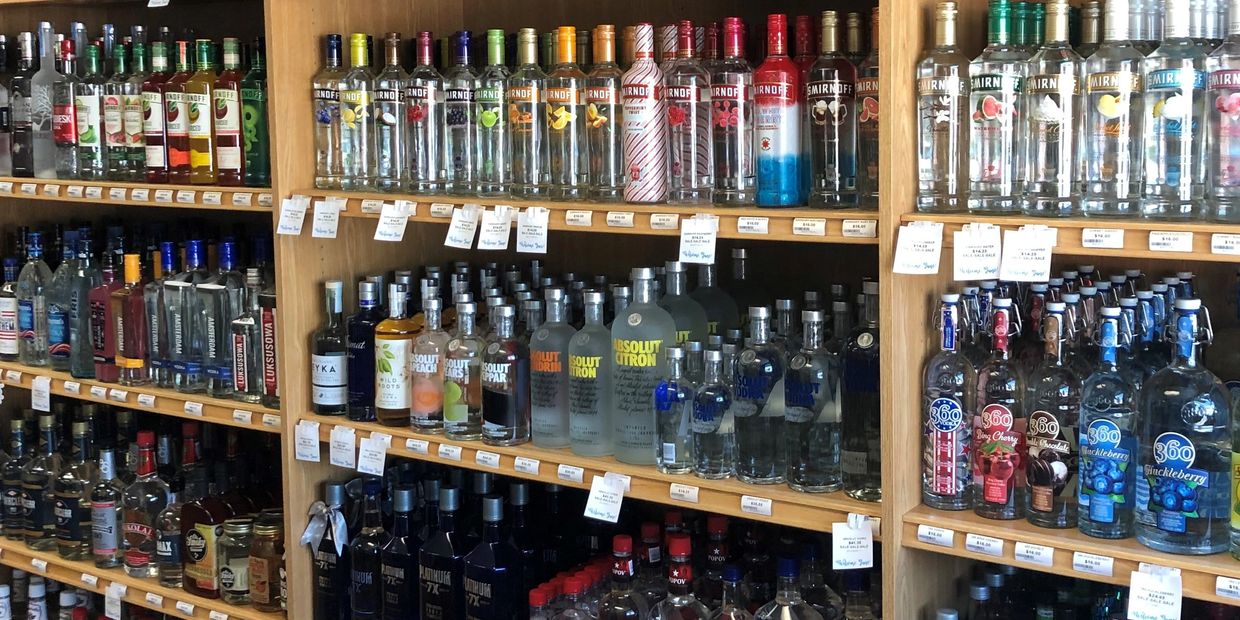 Multiple shelves stocked with vodka. Different vodka brands and vodka flavors 