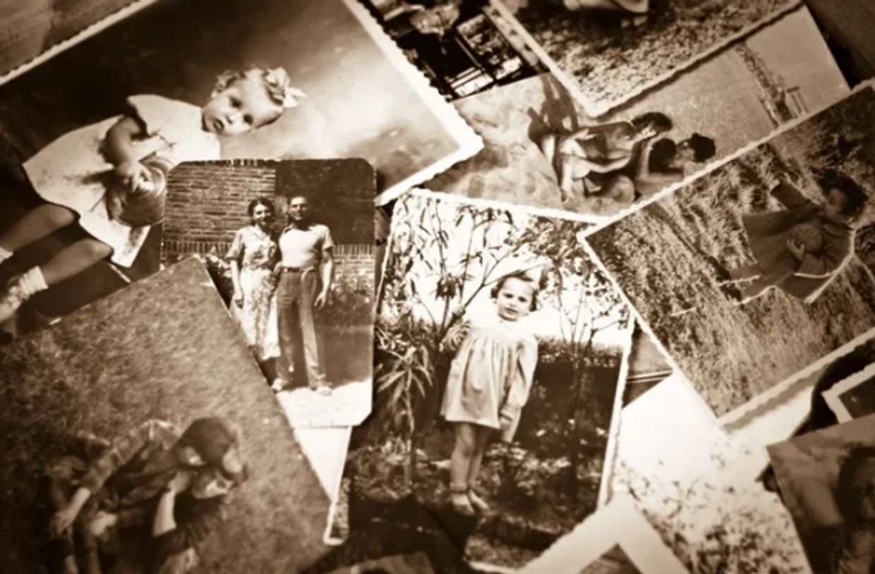 A collection of vintage sepia-toned family photos scattered on a surface.