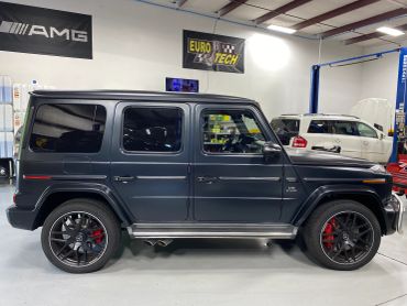 Black Mercedes G-Class SUV parked indoors.