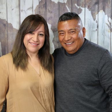 Smiling middle-aged couple posing together indoors.