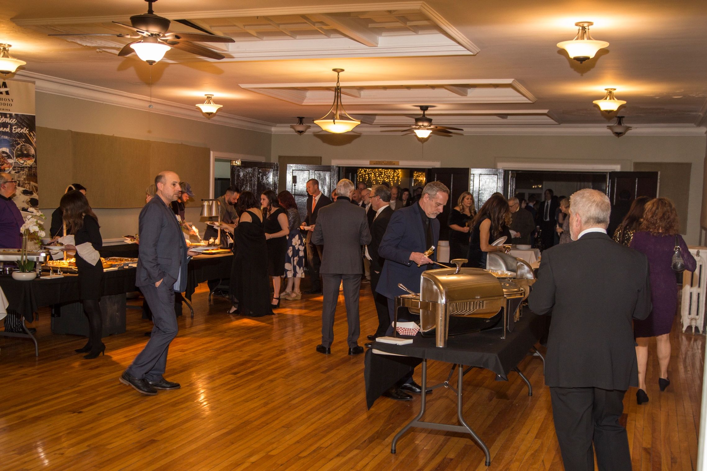 People enjoying a buffet at an indoor formal event.