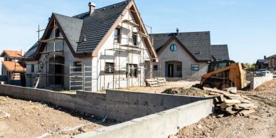 New houses under construction with excavation work in front.