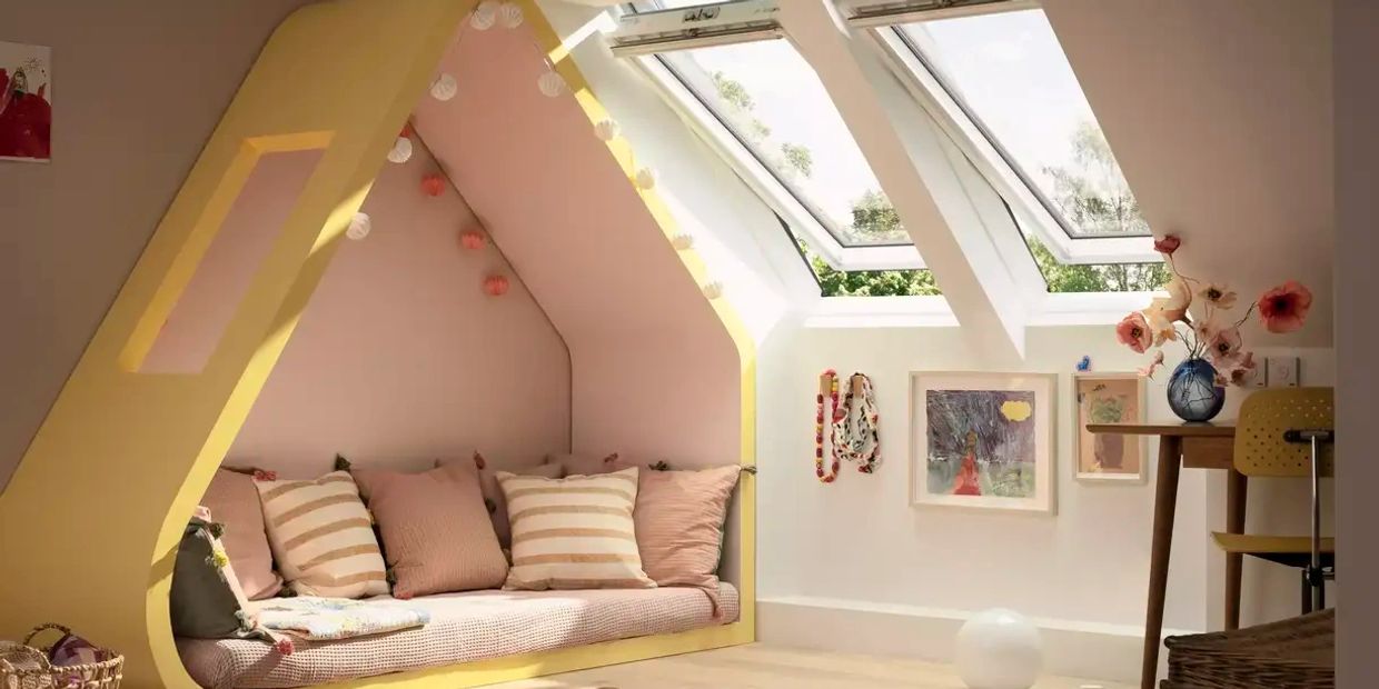 Cozy attic nook with a yellow frame and striped cushions under skylights.