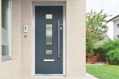 Modern dark blue front door with rectangular glass panels and a sleek handle.