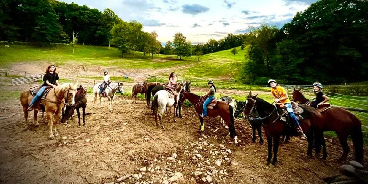 Kids riding horses during a group lesson
