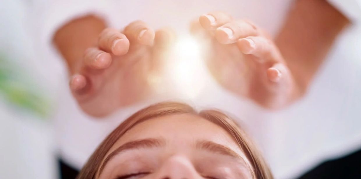 Healing energy being passed through practioner's hands giving Reiki to client